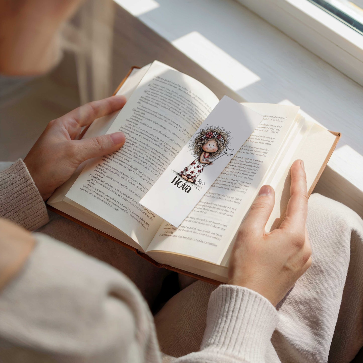 Boekenlegger met naam Nova gebruikt als bladwijzer tussen de pagina's van een open boek