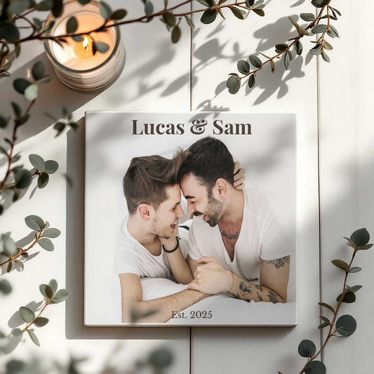 Lifestylefoto van gepersonaliseerd tegeltje op witte houten ondergrond met kaarsje en takje eucalyptus.