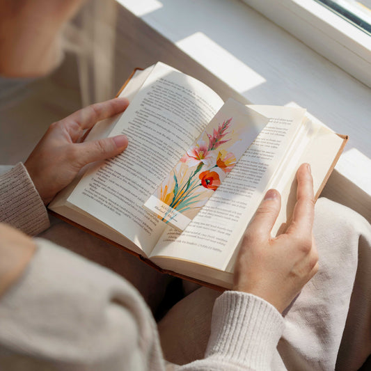 vrouw met open boek en bookmark erin op de pagina, geboorte bloem boekenlegger voor de maand augustus, met kunstzinnige illustratie van Gladiool & Klaproos