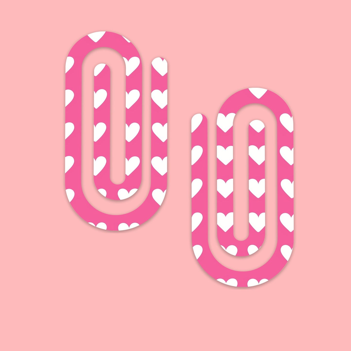 Twee roze jumbo paperclips met wit hartjespatroon op een lichtroze achtergrond