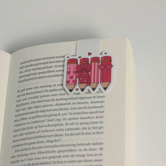 Magnetische boekenlegger vastgeklikt over een pagina van een open boek als bladwijzer