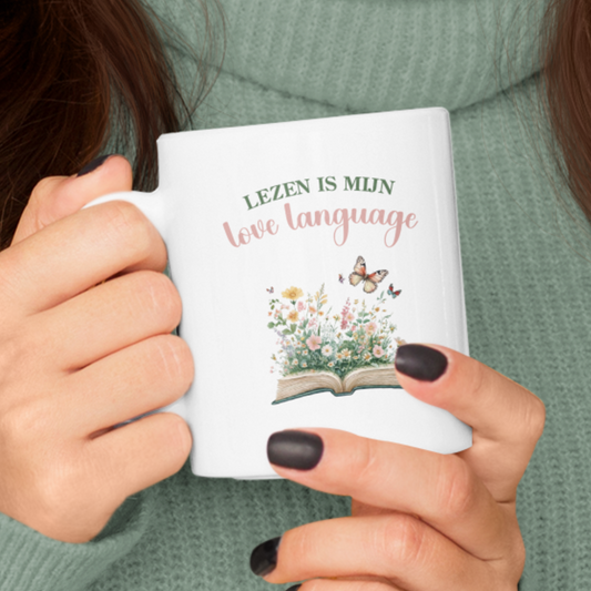 Vrouw houdt witte mok vast met de quote Lezen is mijn love language en illustratie van bloemen en vlinders