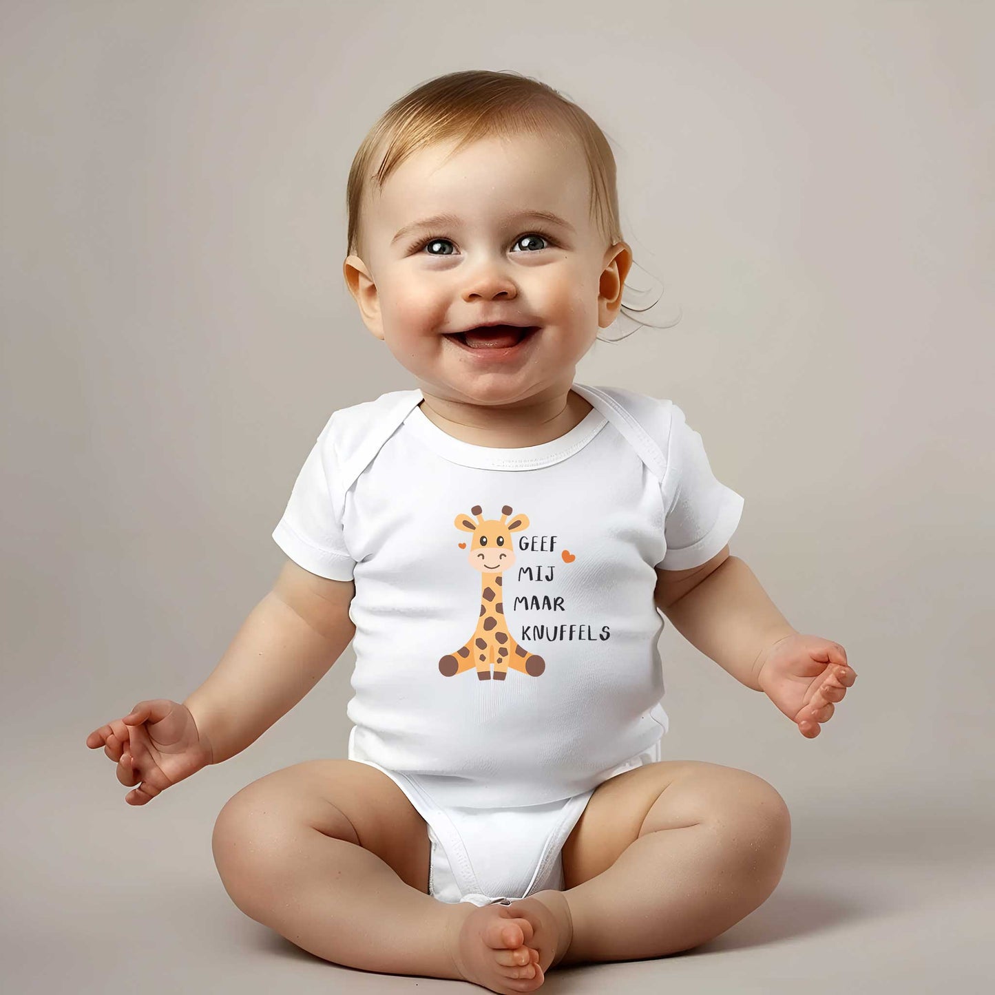Lachende baby met romper met girafje en tekst