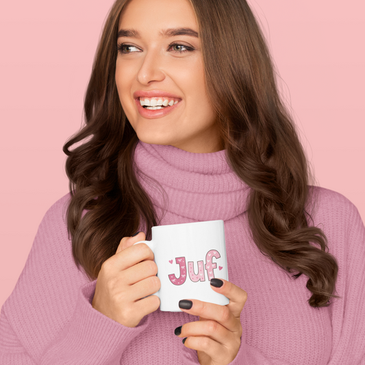 vrouw met bruin haat die een witte mok vasthoudt met de tekst Juf in roze erop