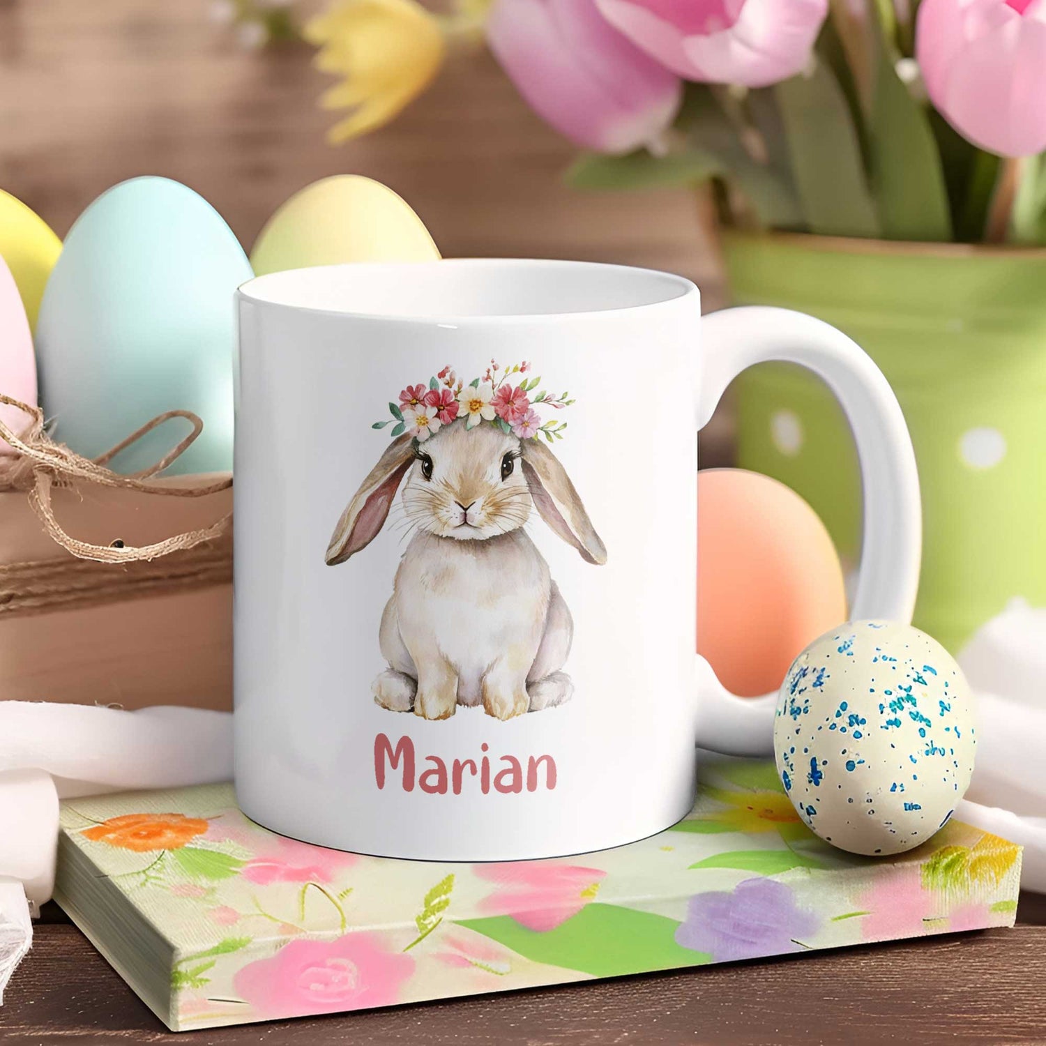 Witte Paasmok met schattig konijntje en bloemenkrans, gepersonaliseerd met de naam Marian, omringd door pastel paaseieren en lente decoratie.