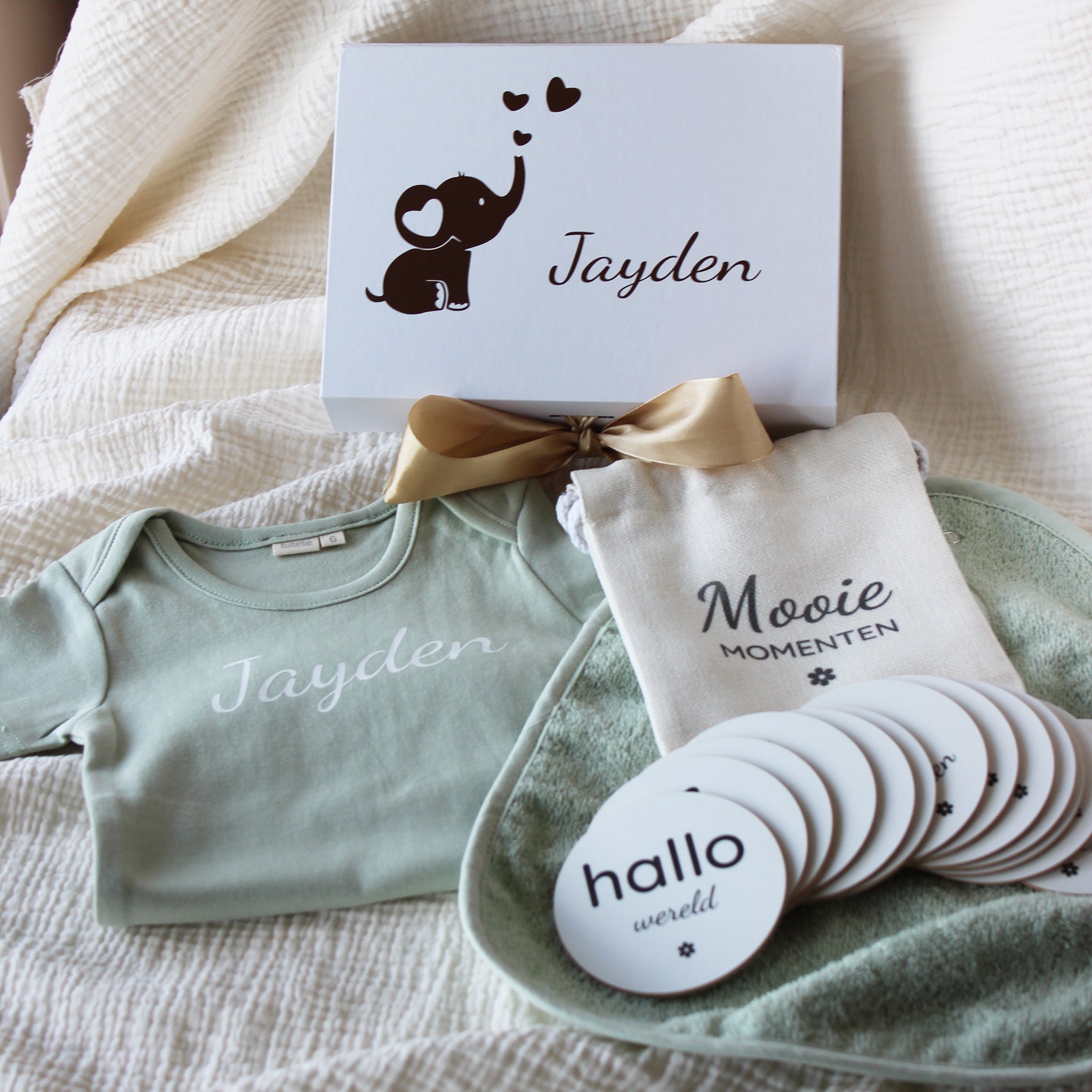 baby giftbox met groen rompertje met naam, slabbetje, mijlpaalschijfjes en linnen zakje in gepersonaliseerde cadeaudoos