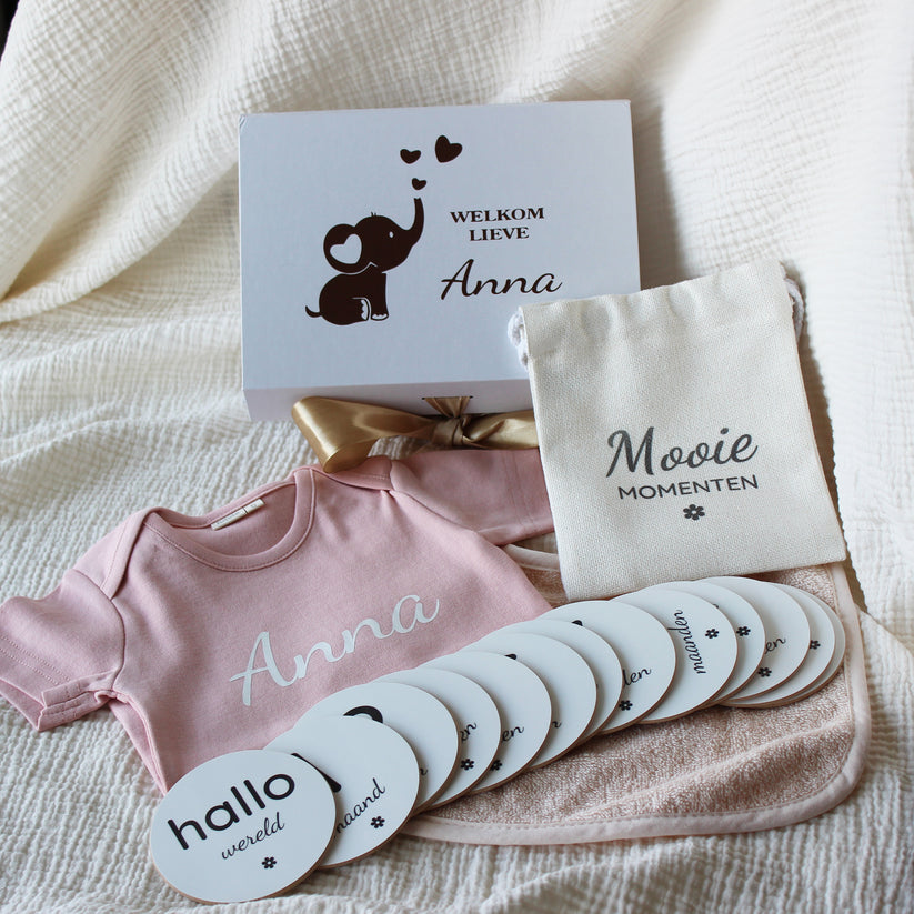 Gepersonaliseerde baby giftbox met naam Anna, rompertje en mijlpaalschijfjes in roze setting