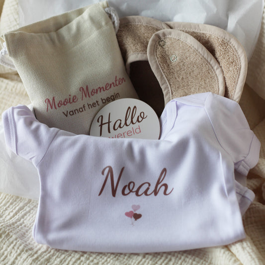 Open baby giftbox met wit rompertje met naam Noah, mijlpaalschijfjes en linnen zakje met tekst Mooie momenten vanaf het begin
