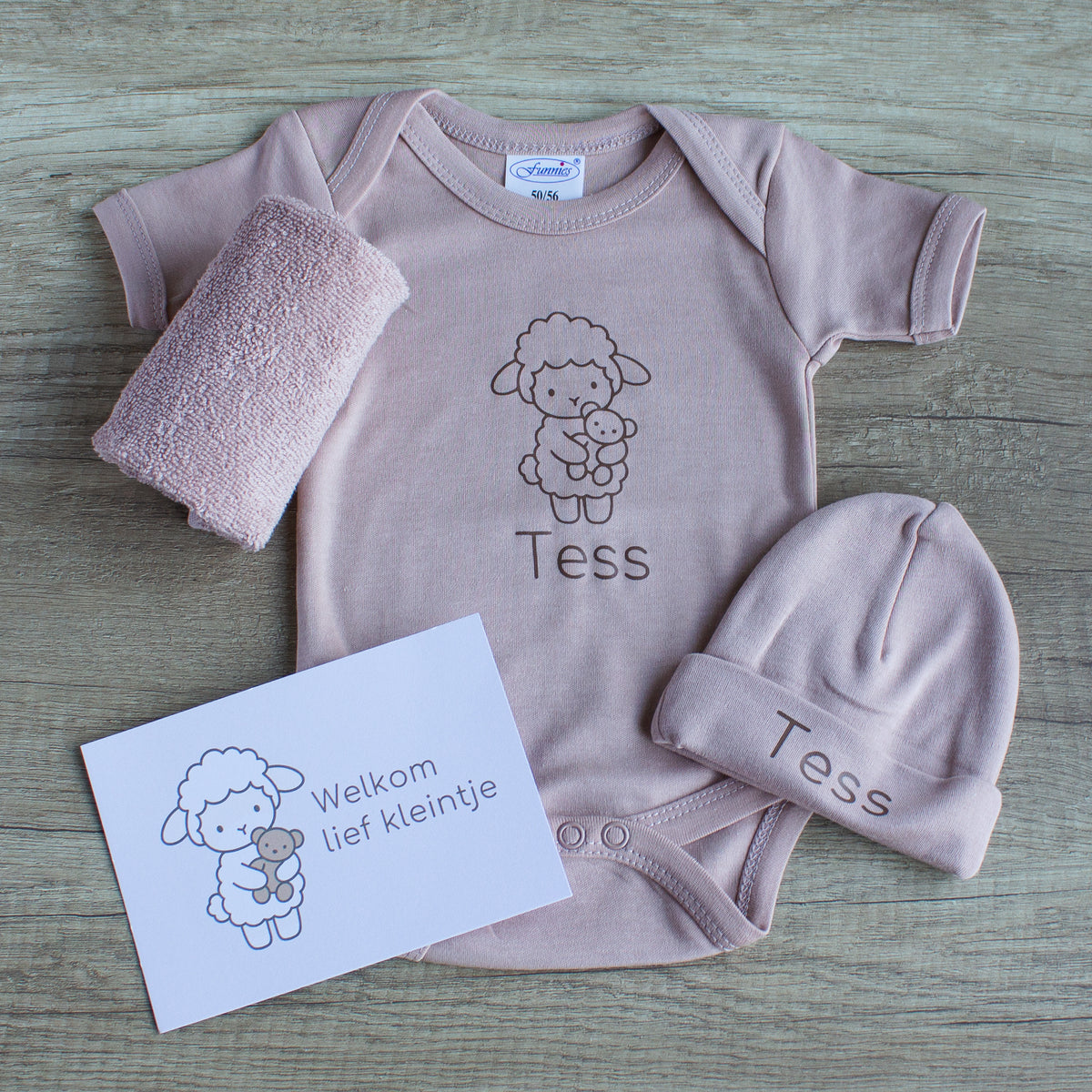 Newborn cadeauset Lammetje in pinkstone met gepersonaliseerde romper en muts met naam Tess, spuugdoekje en kaartje ‘Welkom lief kleintje’.