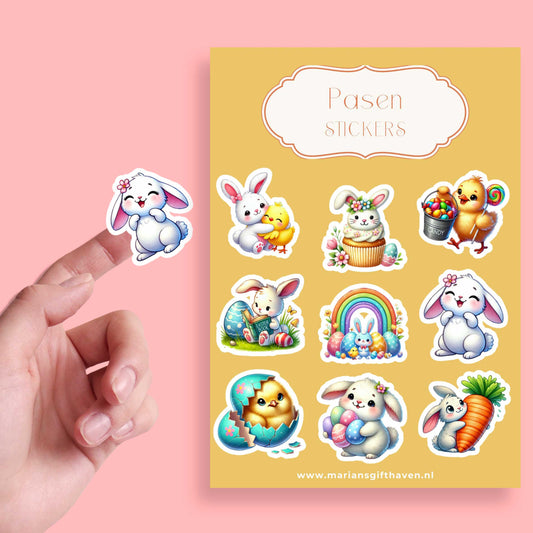 Een stickervel met 9 kleurrijke kawaii Paasstickers, waaronder een konijn met een kuiken, een konijn in een cupcake, en een regenboog met eitjes; op de voorgrond houdt een hand één van de konijntjes-stickers omhoog