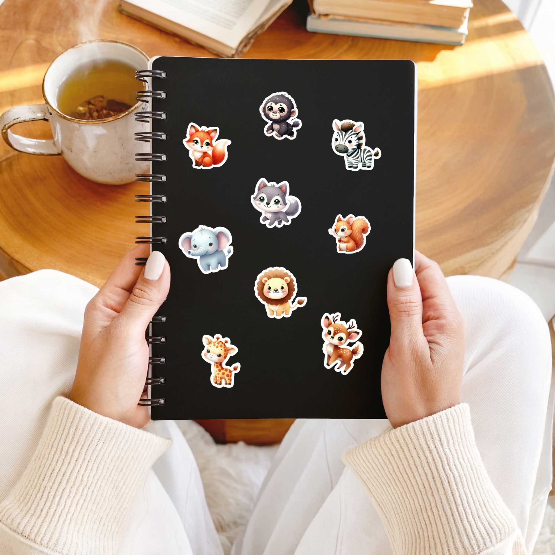 Zwart notitieboek versierd met kawaii bosdieren stickers, zoals aapje, leeuwtje en vosje