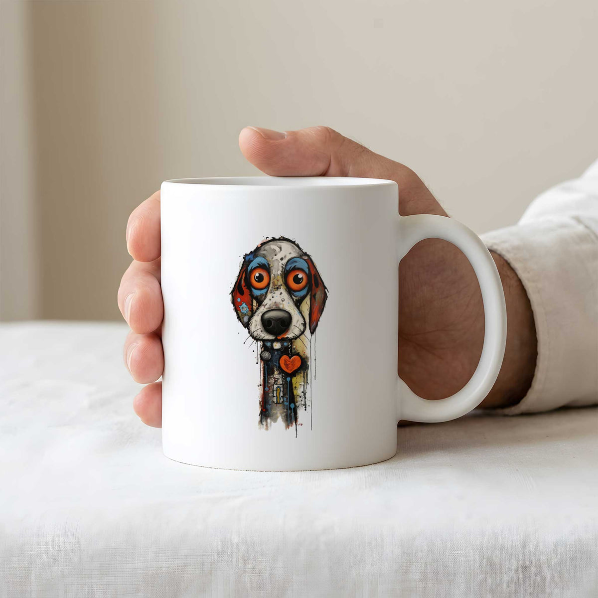 Hand houdt een witte mok vast met een kleurrijke artistieke hond met grote oranje ogen en een rood hartje op de borst.