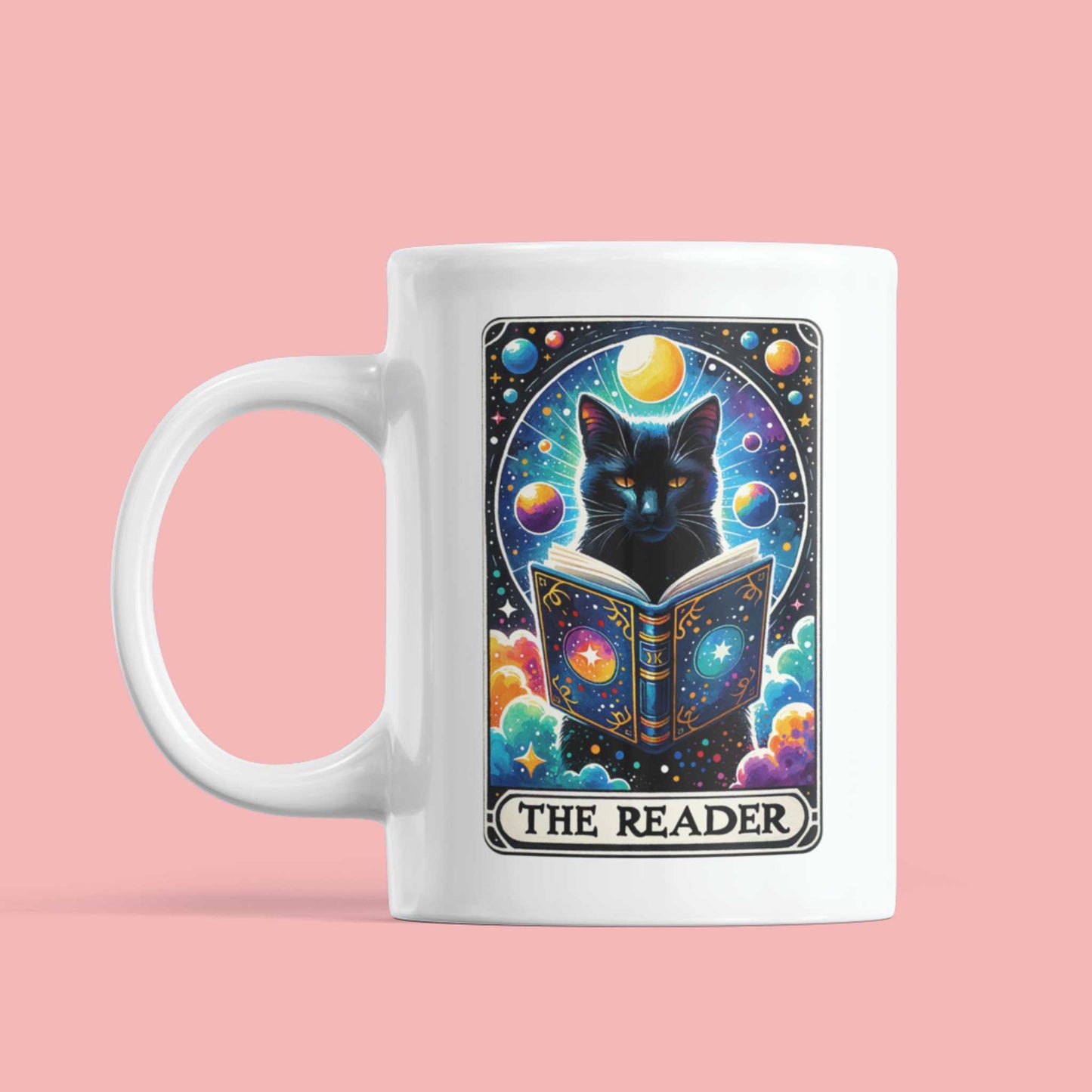 Witte mok met tarotstijl illustratie van kat en planeten, tekst The Reader, op roze achtergrond