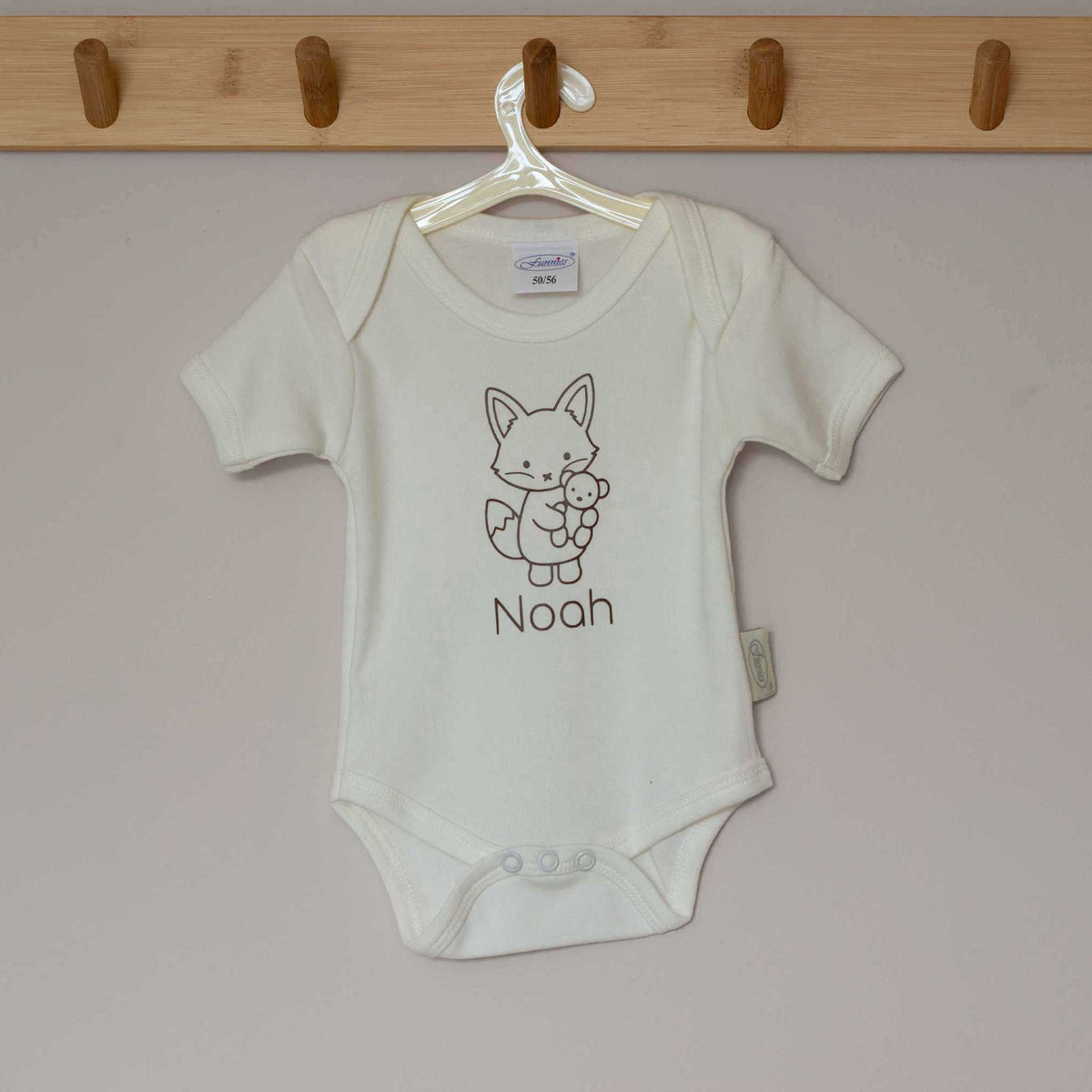 Ecru babyromper aan een hanger, bedrukt met een vosje en gepersonaliseerde naam