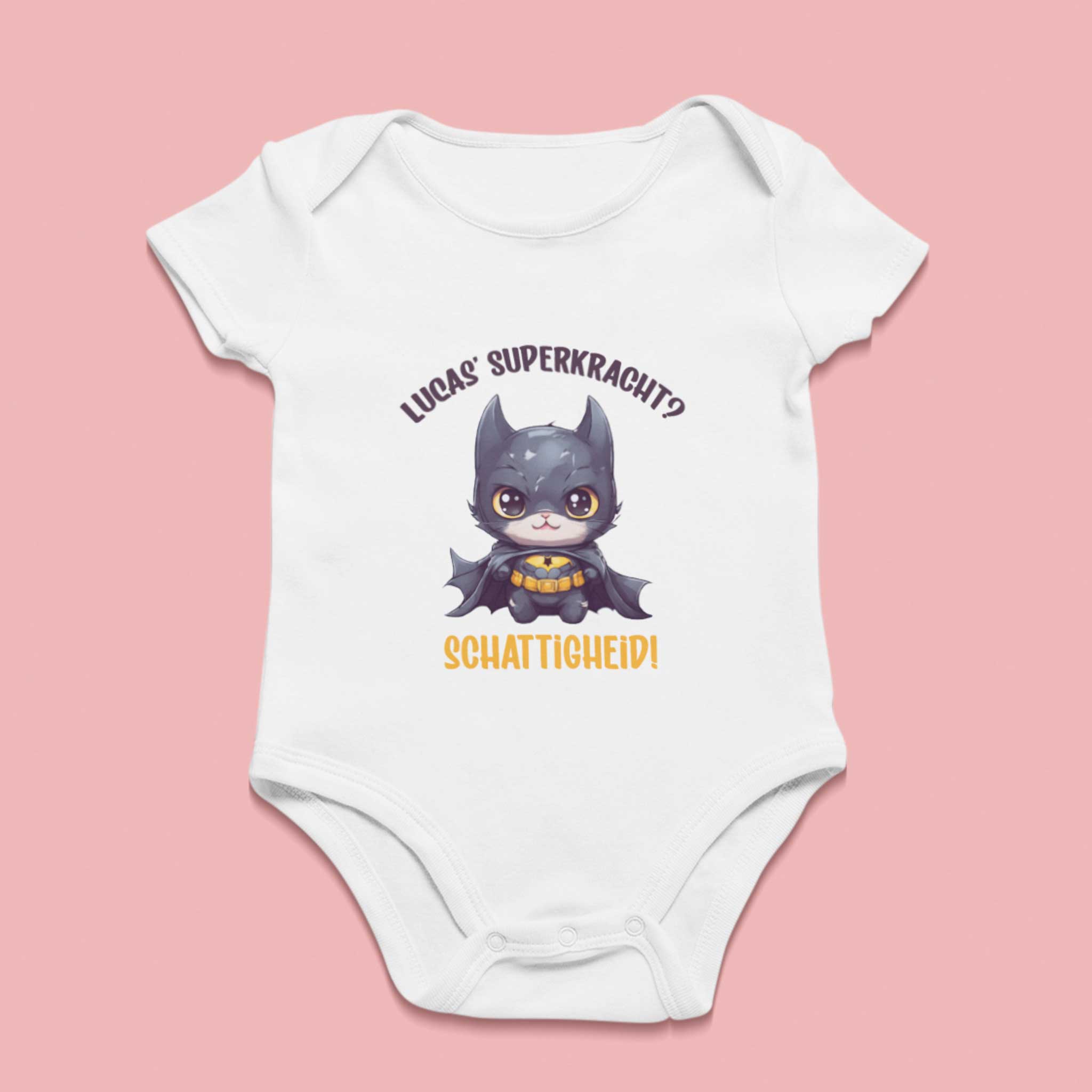 Wit babyrompertje met illustratie van superheld-kat en de tekst “Lucas’ superkracht? Schattigheid!” – gepersonaliseerd kraamcadeau