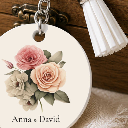 Close-up van gepersonaliseerde bruiloft sleutelhanger met rozenboeket, namen en witte kwast