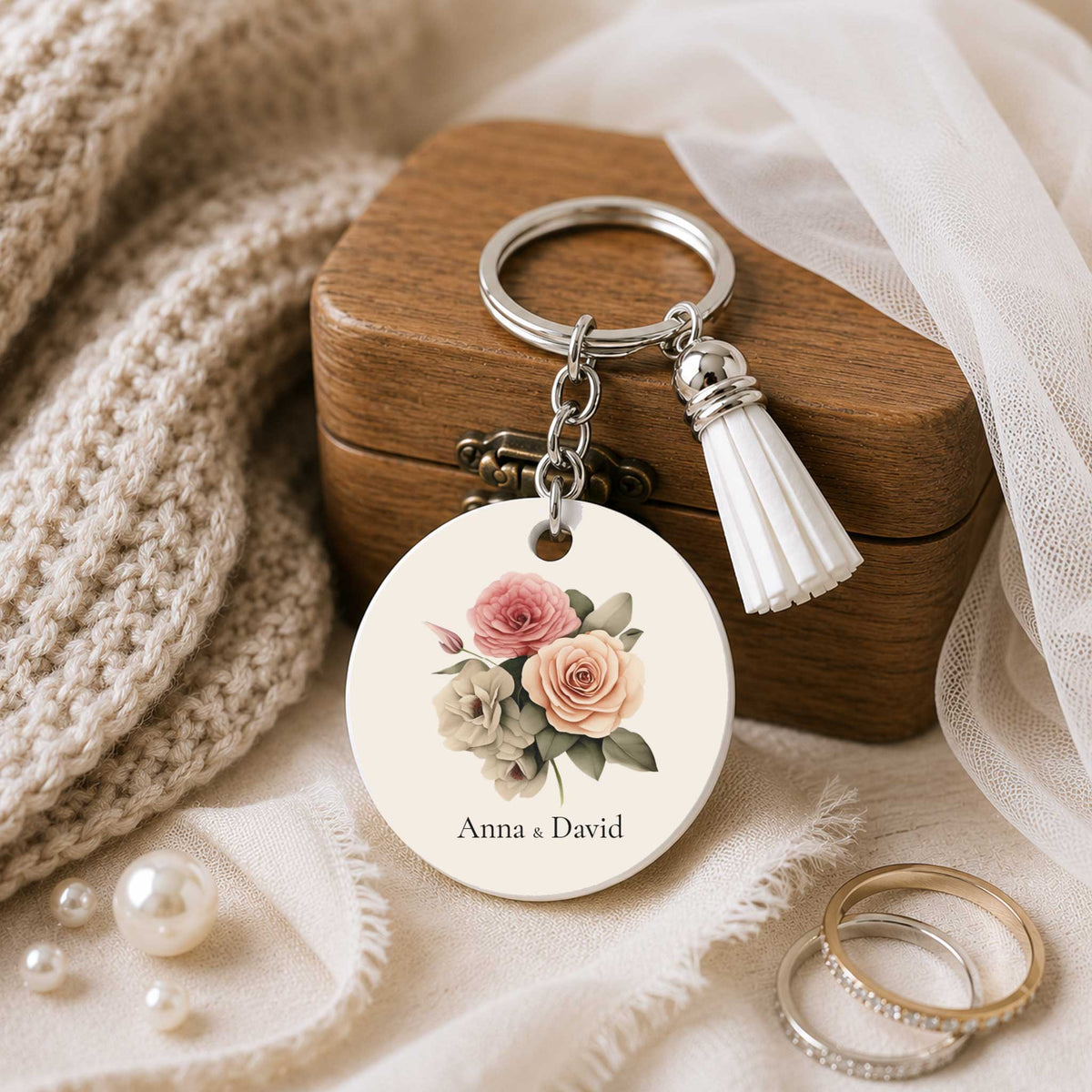 Gepersonaliseerde sleutelhanger met rozen en twee namen bij trouwringen en houten doosje
