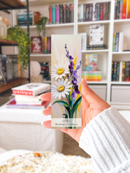 vrouwenhand met geboorte bloem boekenlegger voor de maand april, met  kunstzinnige illustratie van Madeliefje & Lathyrus