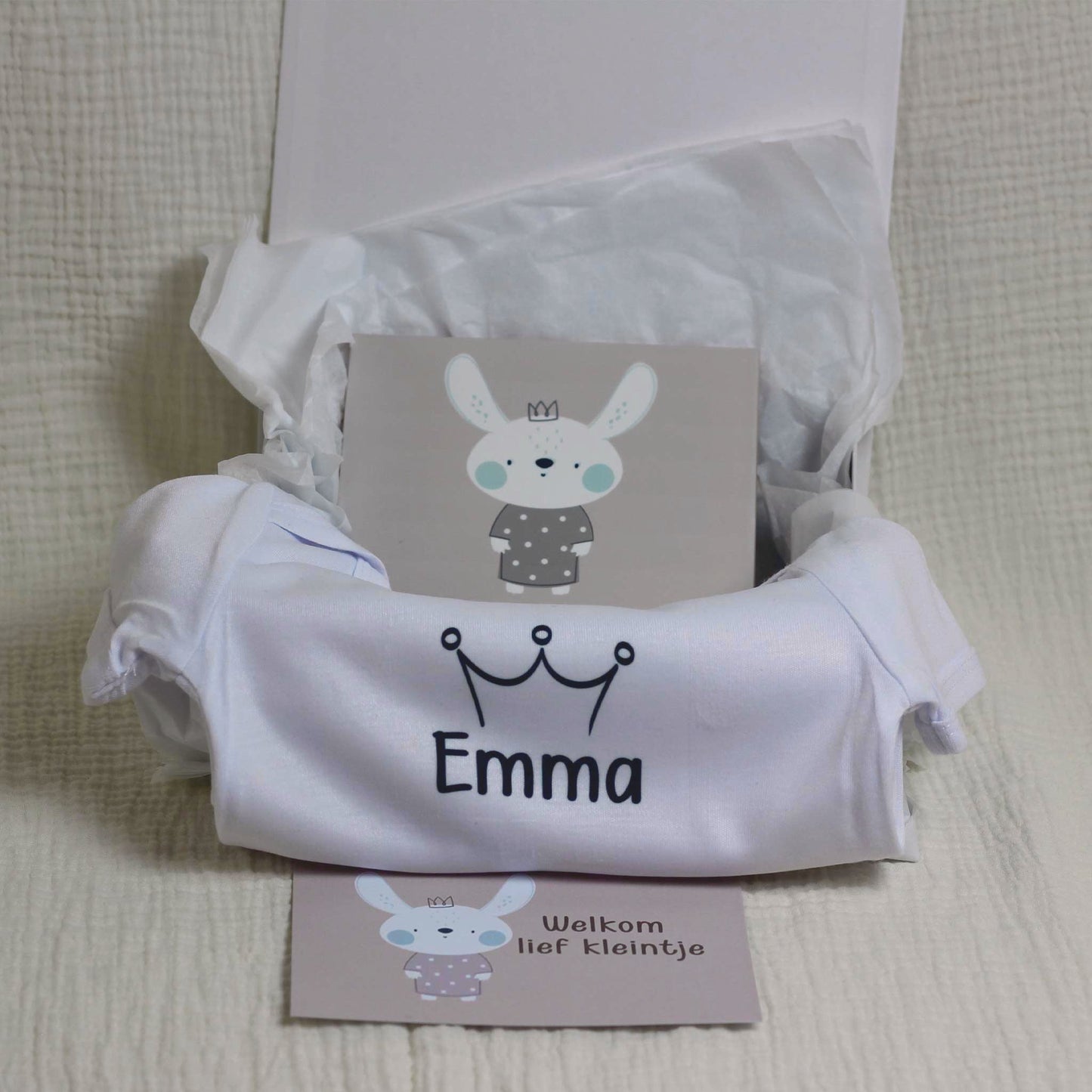 Open cadeaudoos met gepersonaliseerd rompertje, tegeltje en cadeaukaartje voor baby