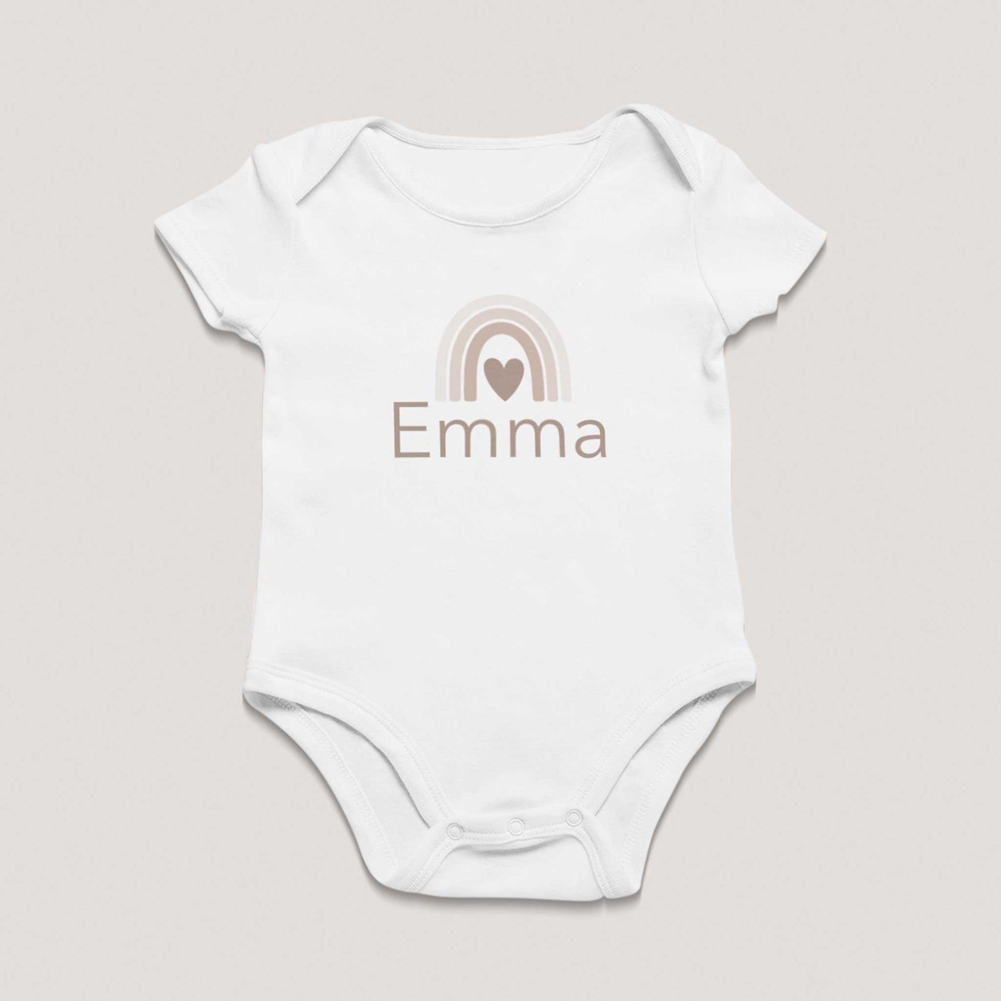 Wit babyrompertje met korte mouwen en gepersonaliseerde naam Emma in beige letters, met een subtiel regenboogontwerp en hartje erboven, liggend op een lichte neutrale achtergrond, geschikt als persoonlijk kraamcadeau voor een pasgeboren baby