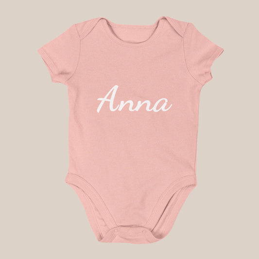Roze babyrompertje met de naam Anna in witte sierletters op de voorkant