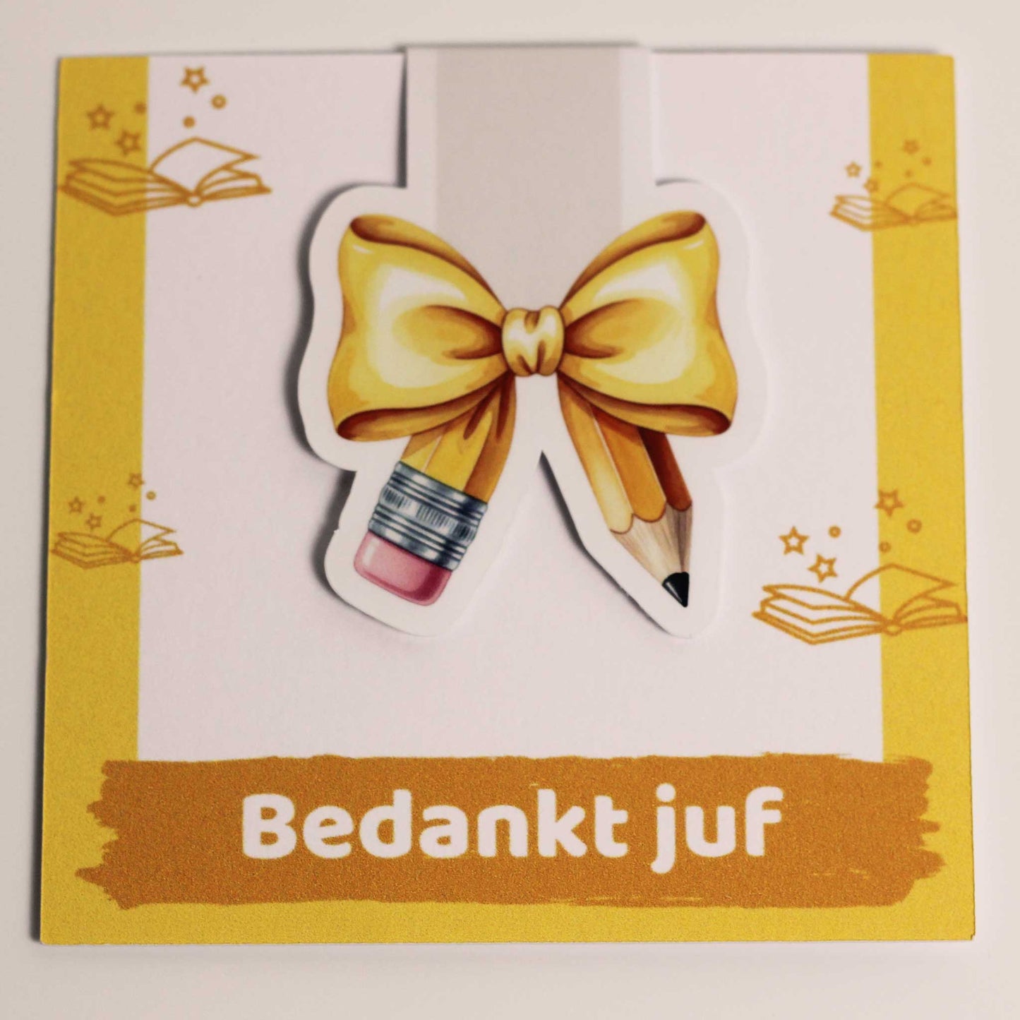 Losse magnetische boekenlegger met geel potlood en strik recht van voren gefotografeerd