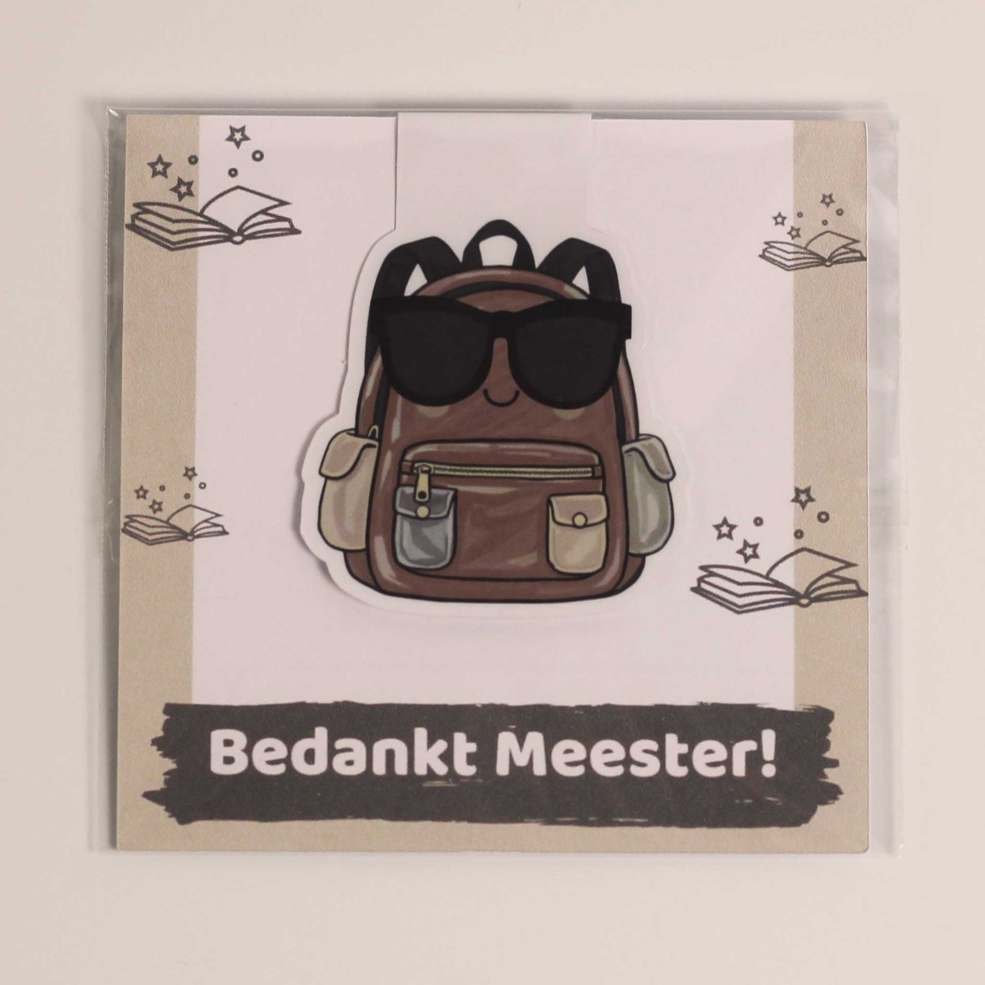 Magnetische boekenlegger voor meester met bruine rugzak en zonnebril op een kaartje met de tekst Bedankt Meester in transparante verpakking