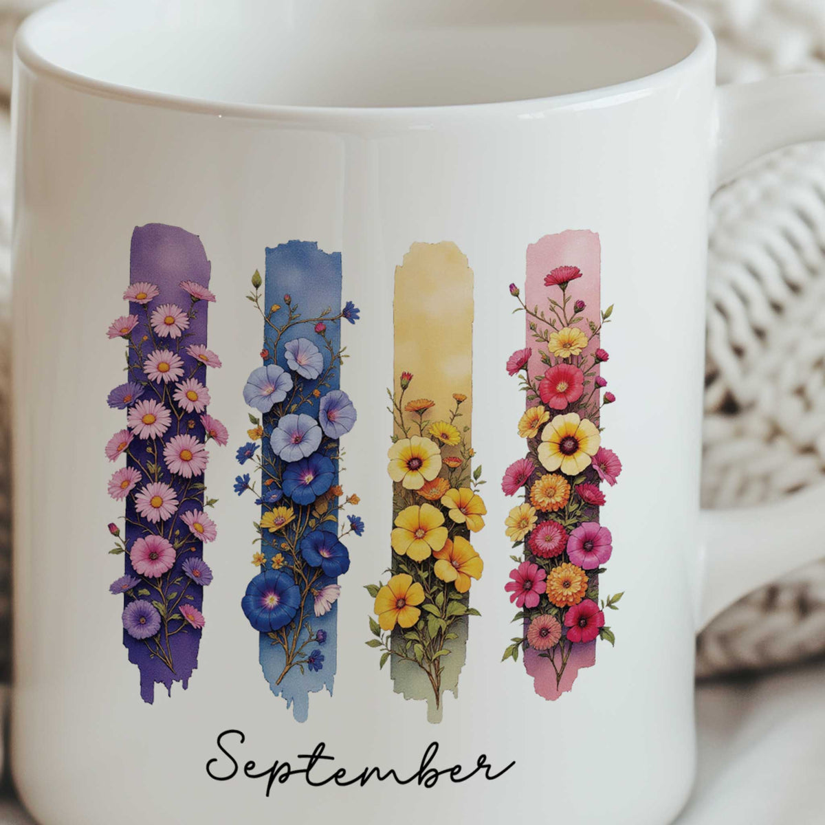 Close-up van een keramische mok met de illustratie van de geboortebloemen aster en winde en de tekst September.