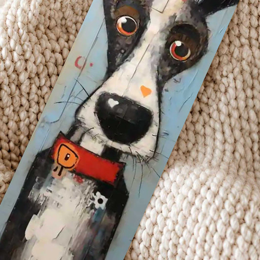 Close-up van boekenlegger met artistieke zwart-witte hond met grote ogen en rode halsband op een beige gebreide deken.