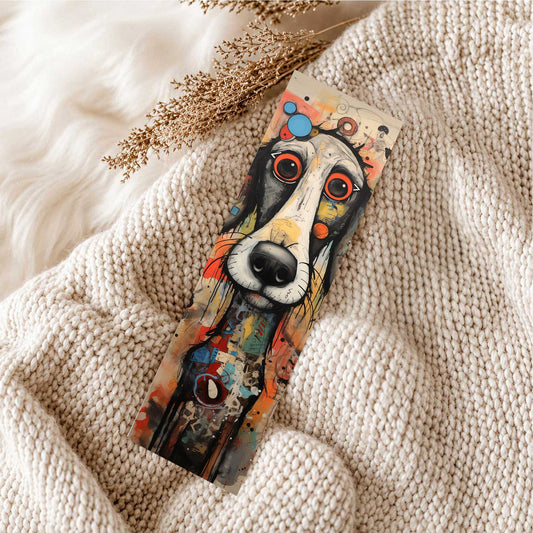 Boekenlegger Hond Kunst met zwart-witte hond en grote rood-oranje ogen, liggend op een zachte beige gebreide deken.
