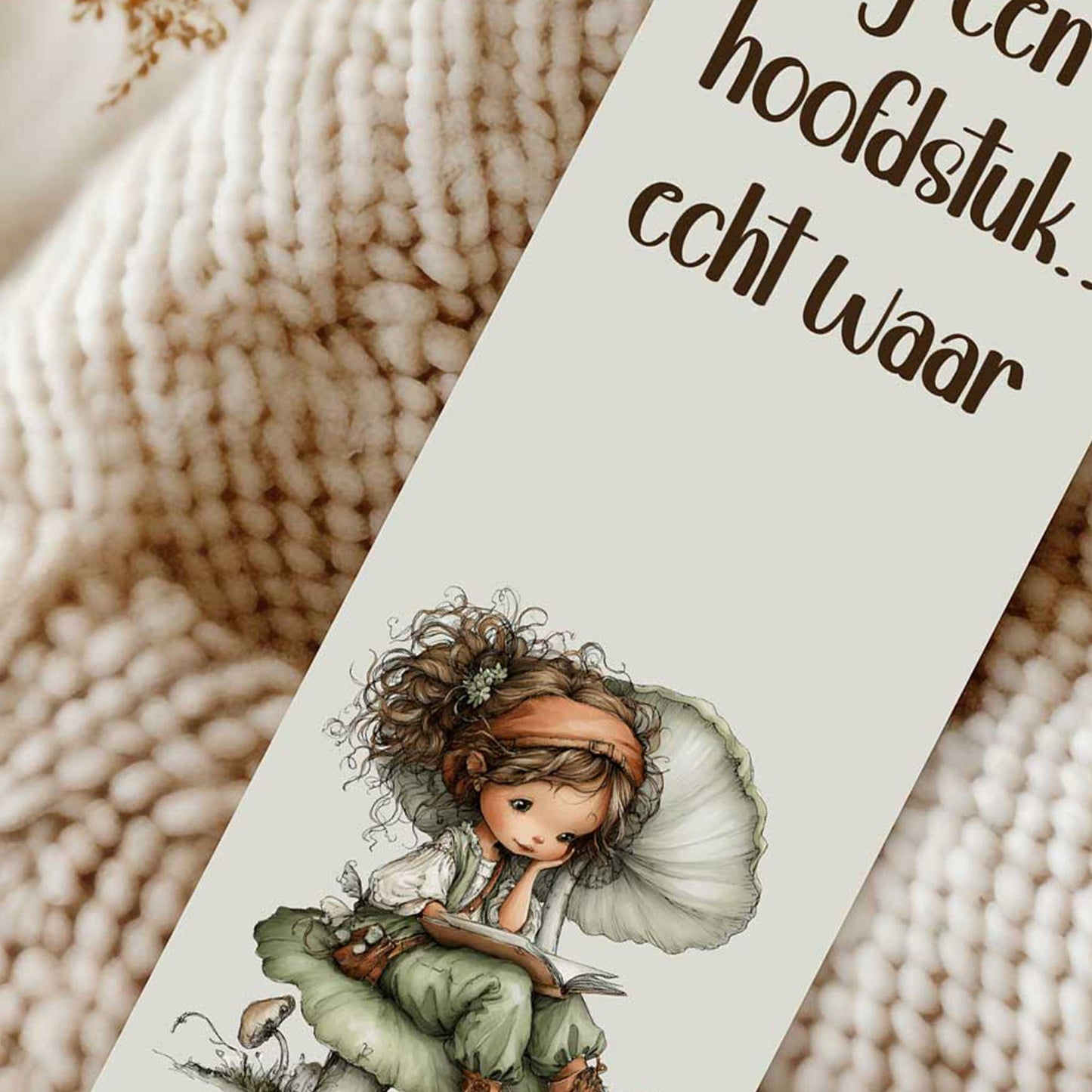 Close-up van een boekenlegger met de tekst "Nog één hoofdstuk... echt waar!", een lezende fee op een paddenstoel en een roze kwastje.