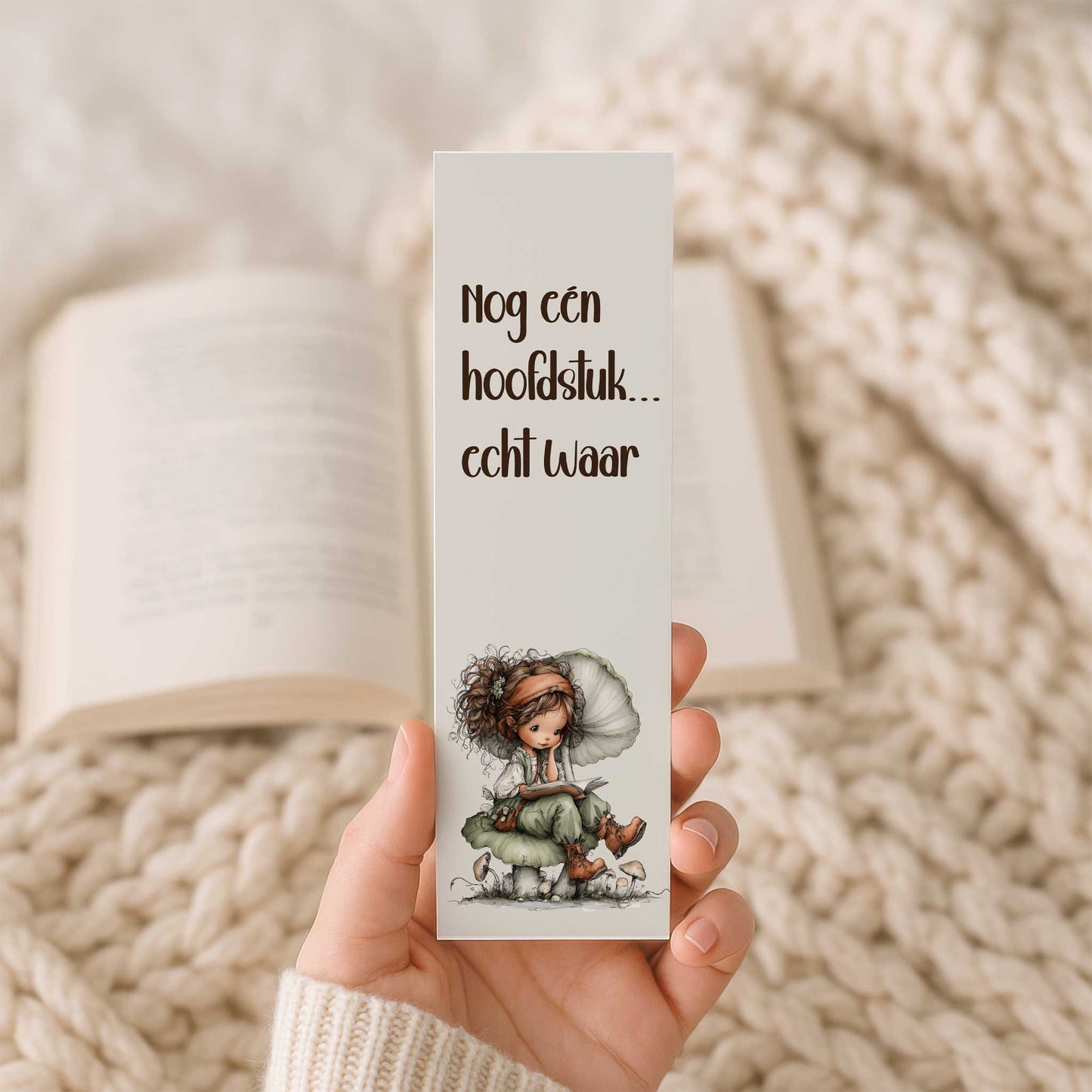 Hand die een boekenlegger vasthoudt met de tekst "Nog één hoofdstuk... echt waar!" en een leesfee op een paddenstoel.