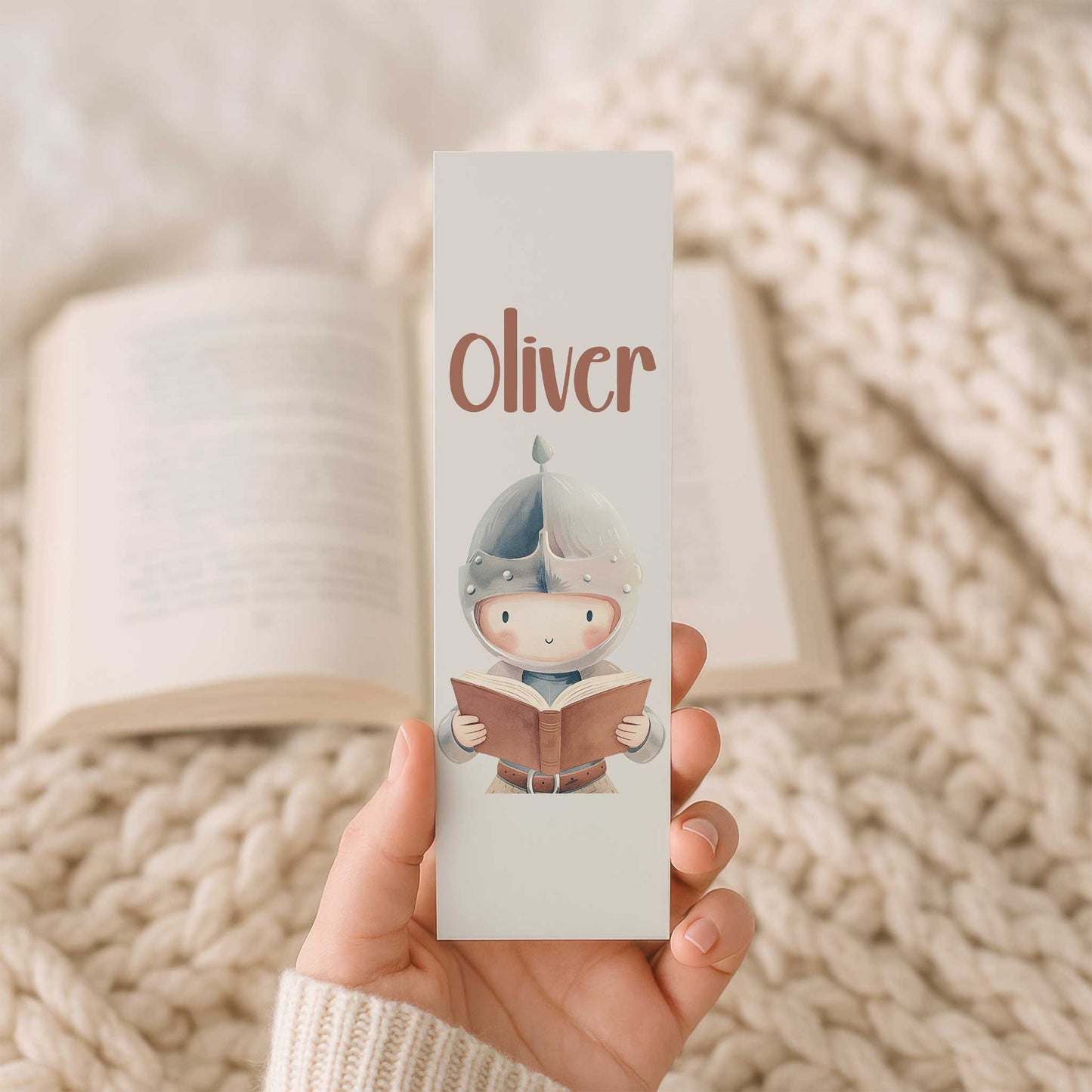 Productfoto van een gepersonaliseerde boekenlegger met de naam Oliver en een lezende ridder die wordt vastgehouden.