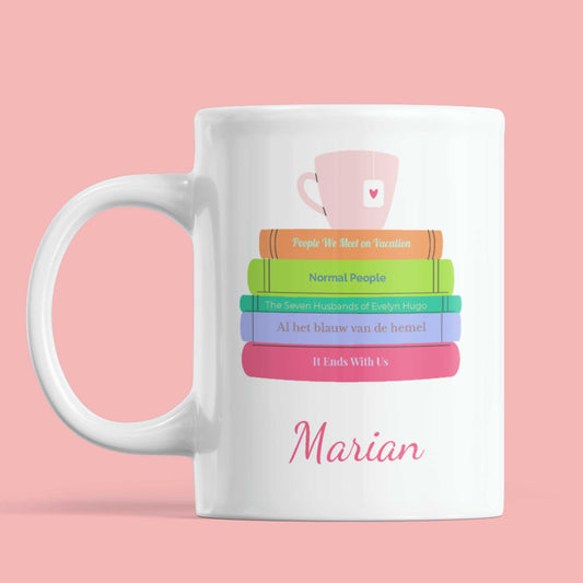 Witte mok met boekenstapel illustratie en naam Marian, keramische mok op roze achtergrond
