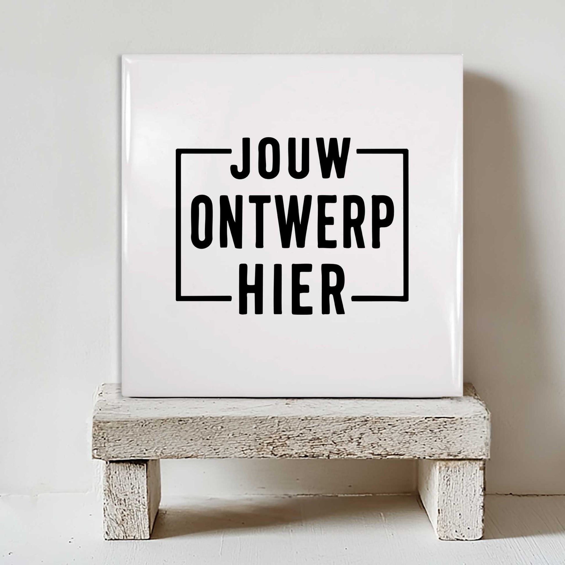 Wit keramisch tegeltje van 15x15 cm met de tekst 'Jouw Ontwerp Hier' als voorbeeld van een gepersonaliseerd tegeltje