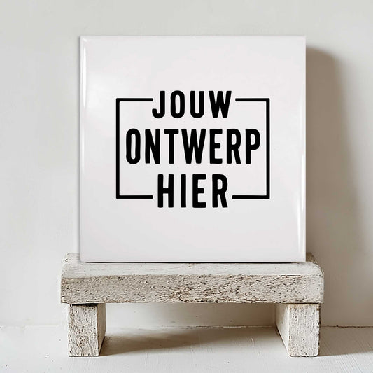 Wit keramisch tegeltje van 15x15 cm met de tekst 'Jouw Ontwerp Hier' als voorbeeld van een gepersonaliseerd tegeltje