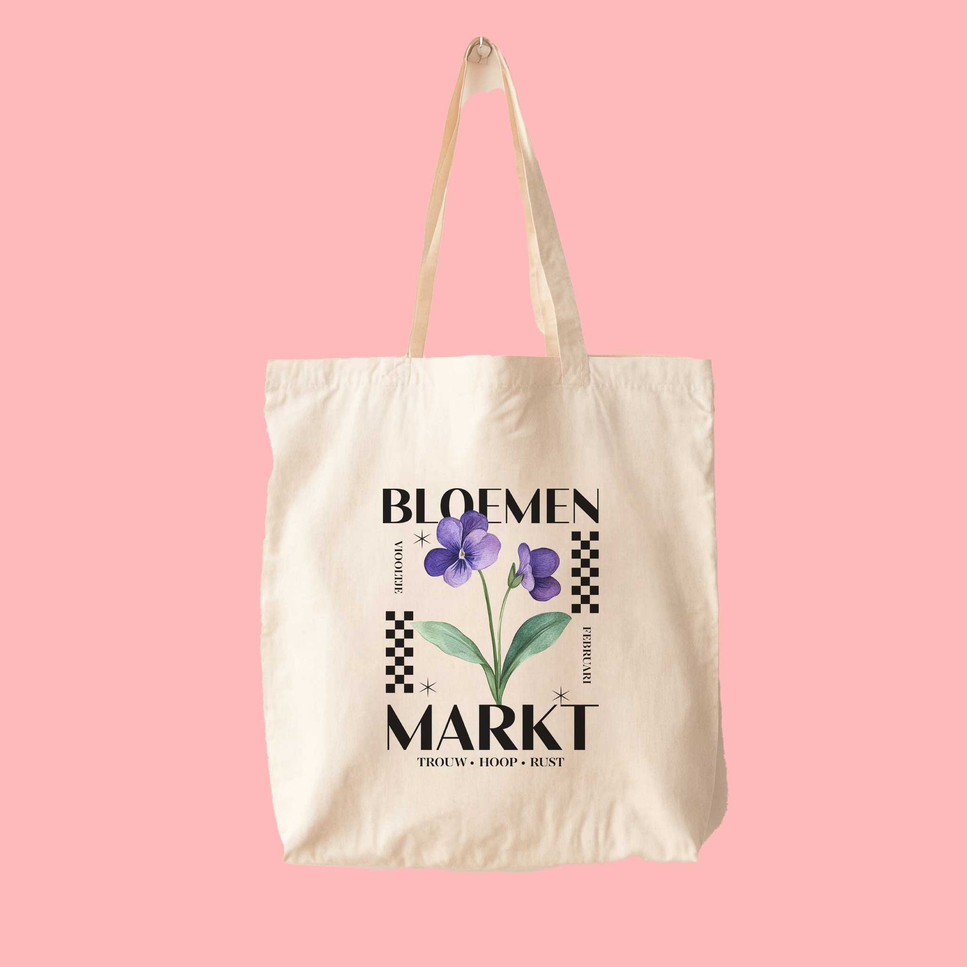 totebag met  de tekst bloemenmarkt en een illustratie van een geboortebloem van de maand februari, een viooltje. Met onderaan de kernwoorden van deze maand : trouw, hoop, rust