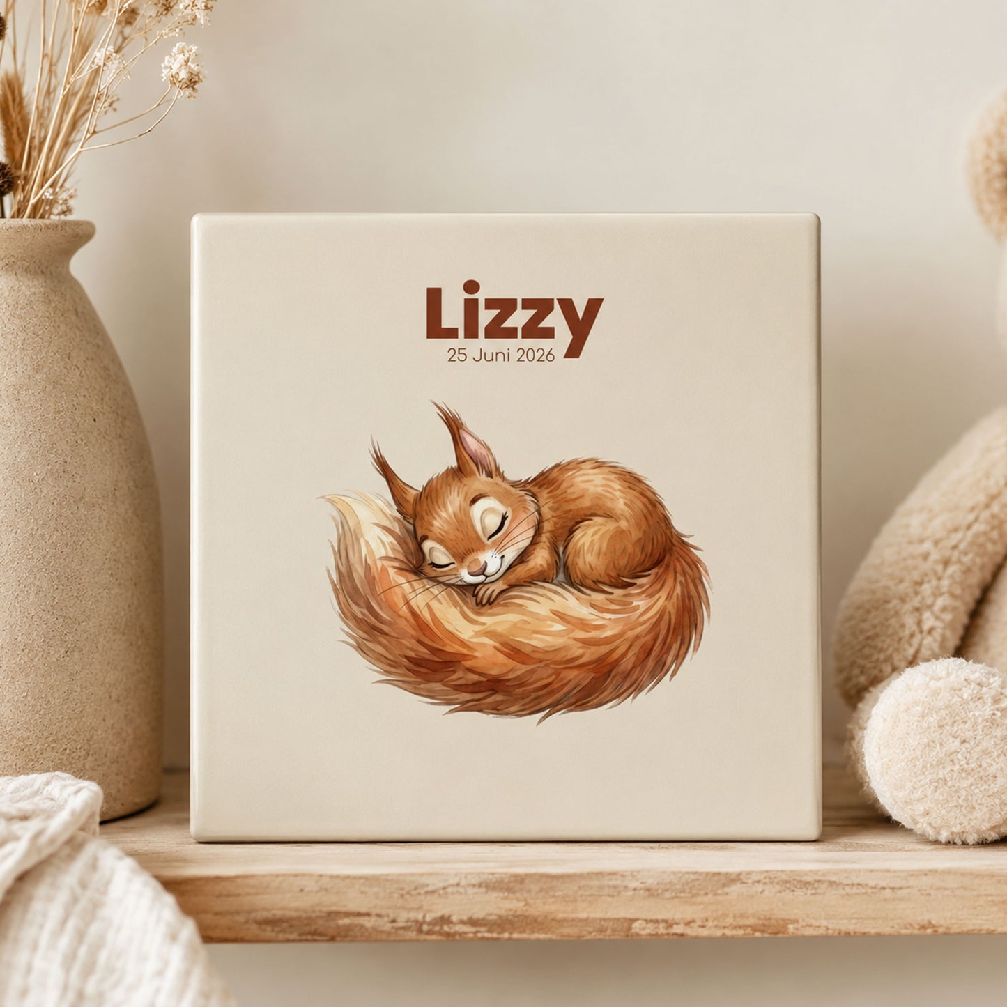 Gepersonaliseerd babytegeltje met slapend eekhoorntje, naam en geboortedatum op houten plank naast teddybeer en beige droogbloemen in warme neutrale sfeer.