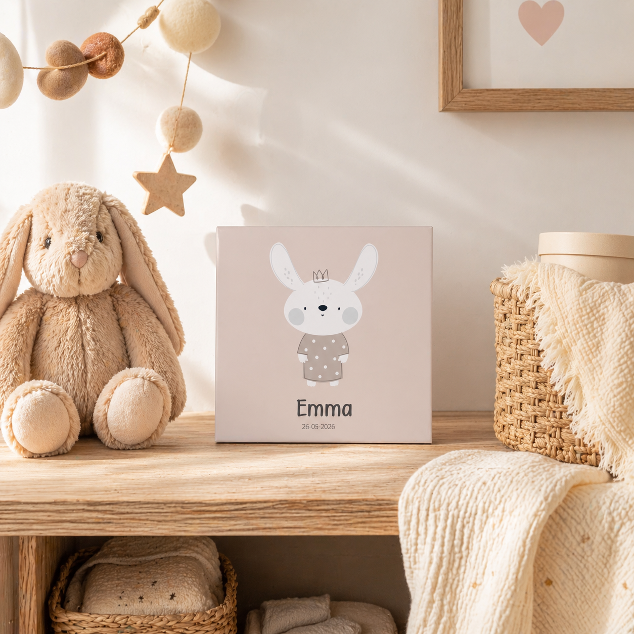 Gepersonaliseerd geboortetegeltje met konijntje en kroontje, naam Emma en datum, op houten plank naast knuffel in babykamer