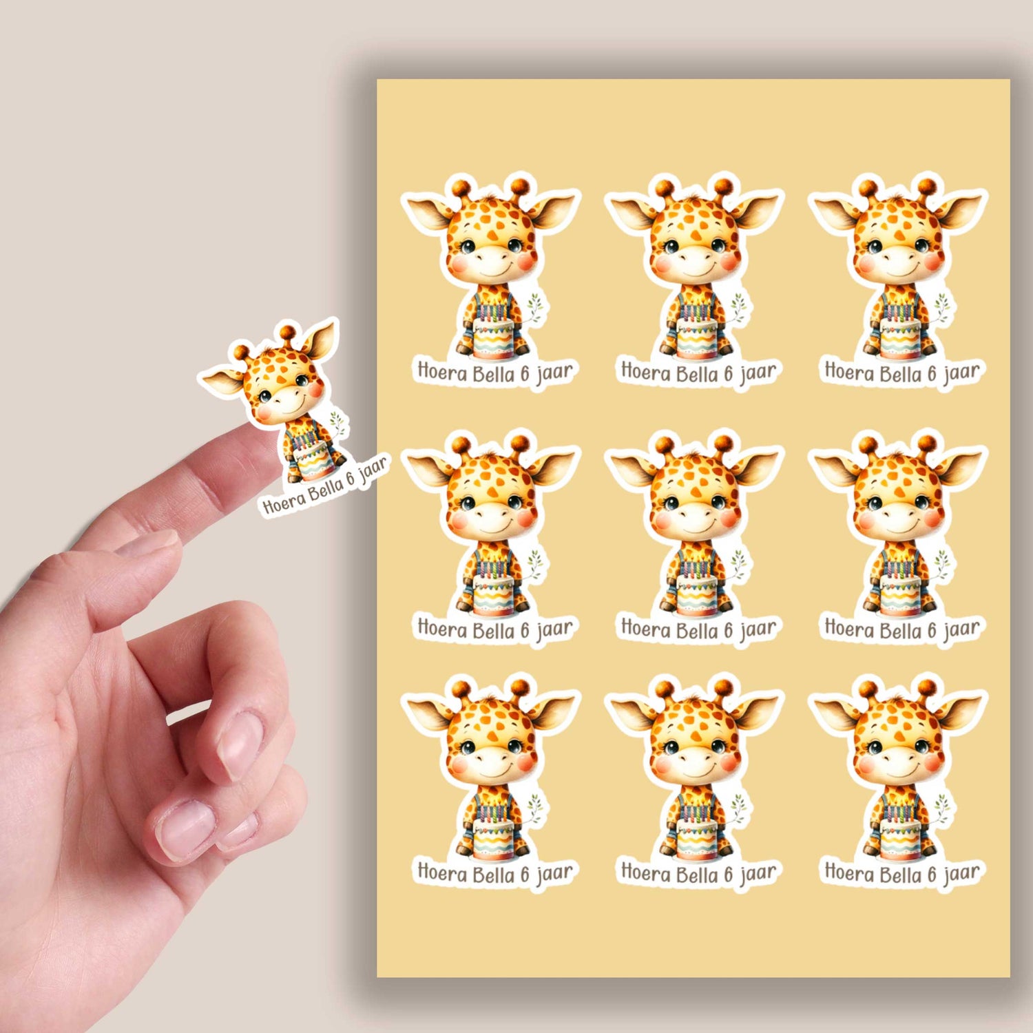 Persoonlijk giraf stickervel met 9 stickers voorzien van naam en leeftijd, naast een close-up van een losse sticker op een vingertop.