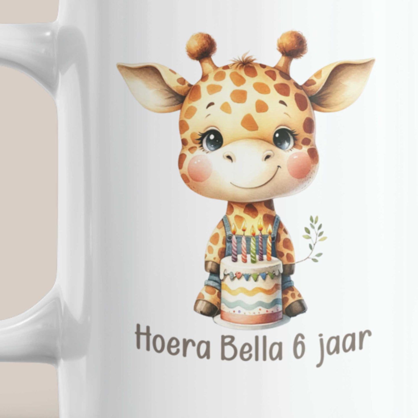 Close-up van de bedrukking op een witte mok met een schattige giraf, verjaardagstaart en de gepersonaliseerde tekst 'Hoera Bella 6 jaar'.