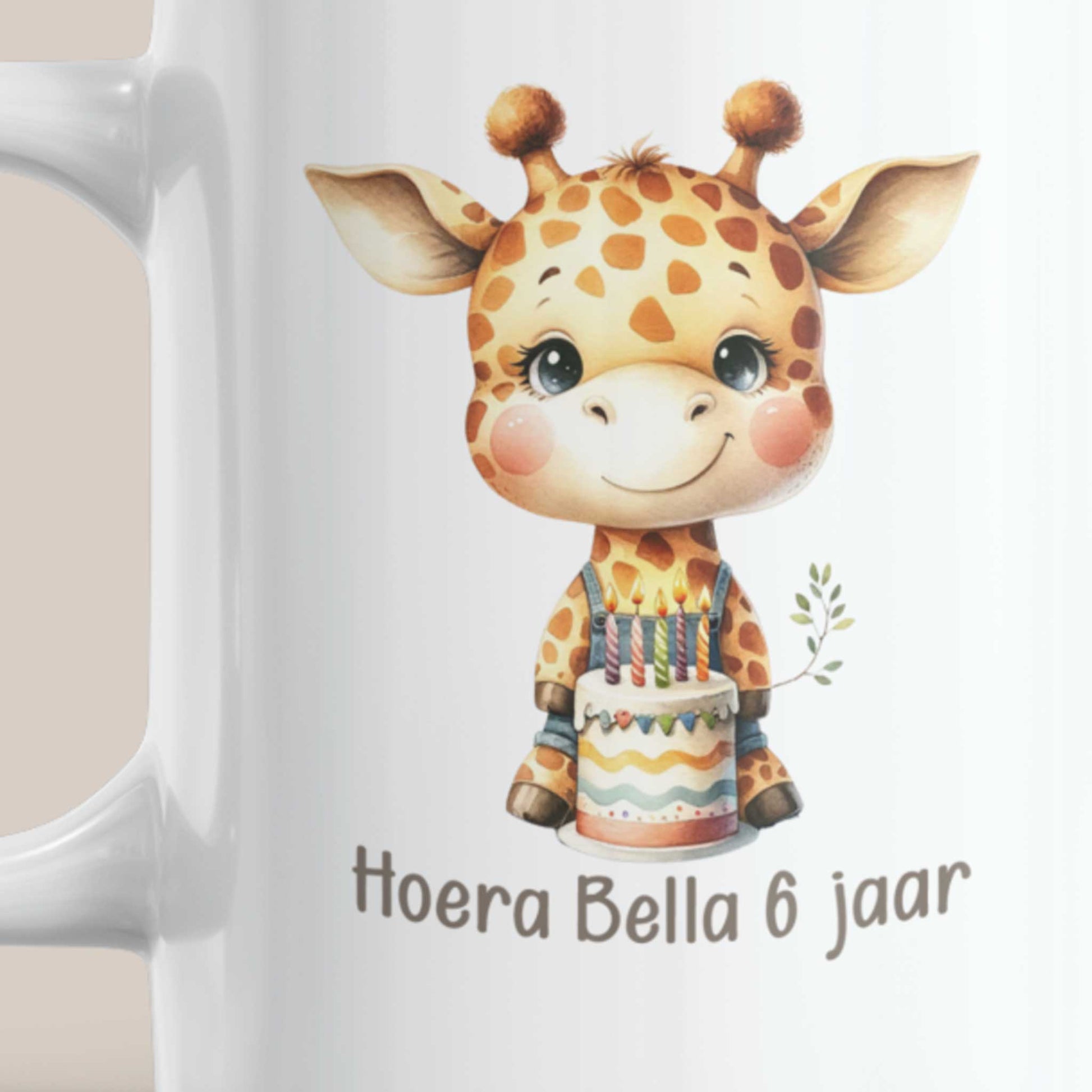 Close-up van de bedrukking op een witte mok met een schattige giraf, verjaardagstaart en de gepersonaliseerde tekst 'Hoera Bella 6 jaar'.