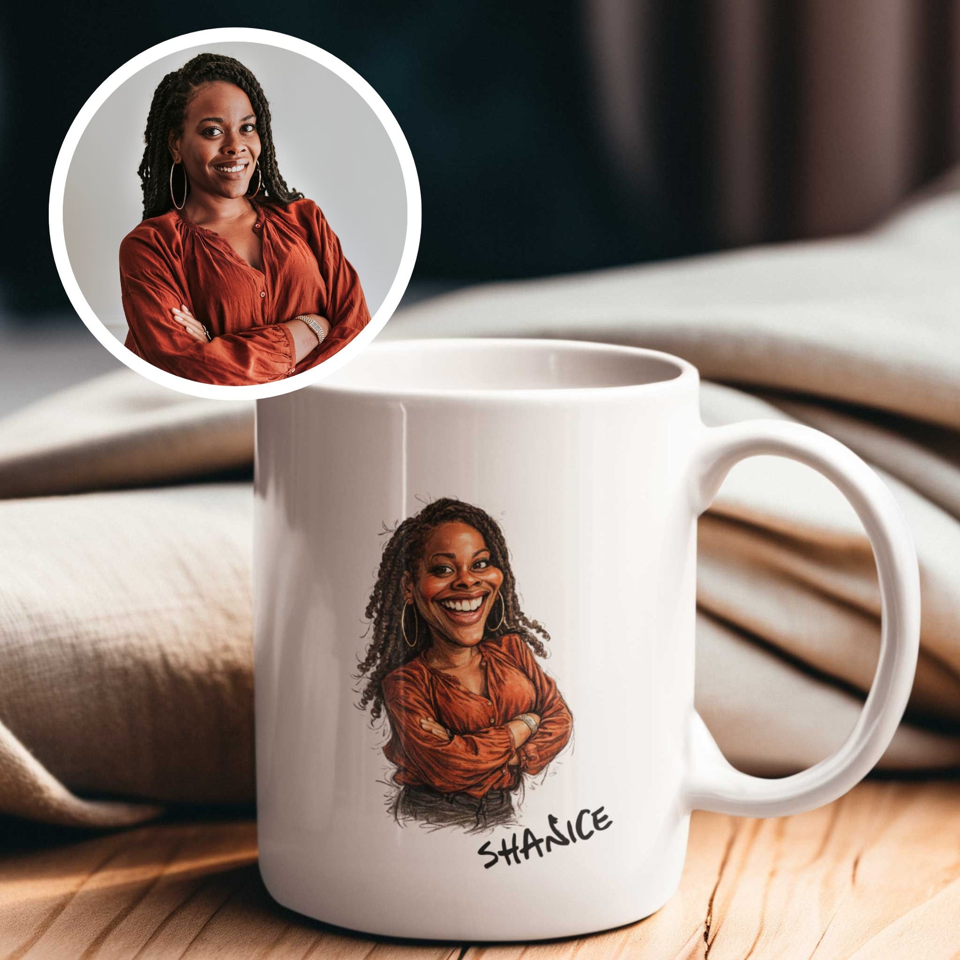 Witte keramische mok met een handgetekende karikatuur van een lachende vrouw met lange twists, grote oorbellen en een roestbruine blouse. Onder de karikatuur staat de naam Shanice in speels handschrift. Linksboven staat de originele foto van de vrouw als rond voorbeeldbeeld, zodat het voor-en-na effect van de gepersonaliseerde karikatuur zichtbaar is. De mok staat op een houten tafel met een warme, zachte achtergrond.