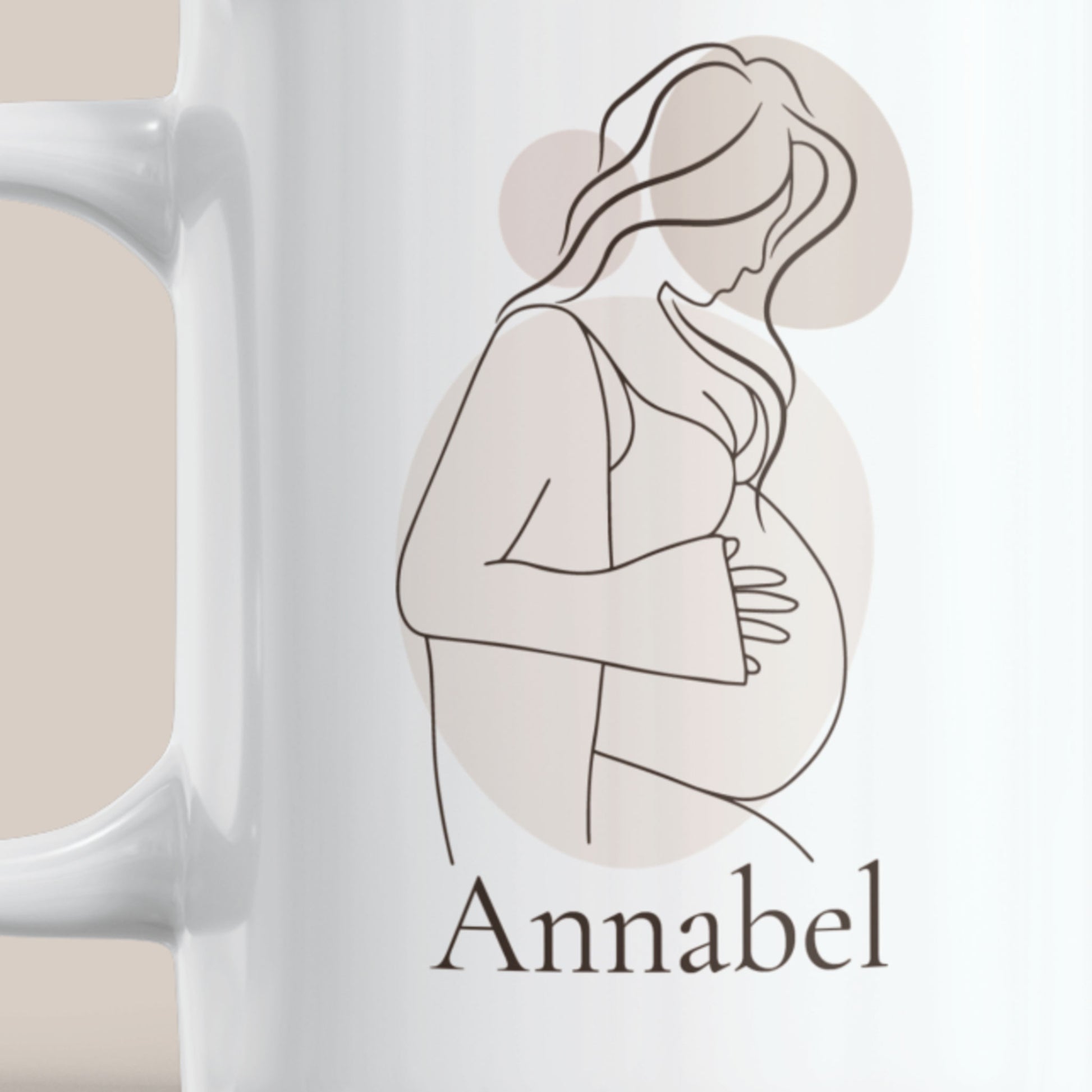 Witte keramische zwangerschapsmok met minimalistische lijntekening van een zwangere vrouw in neutrale beige tinten en de naam Annabel. Detailfoto van het gepersonaliseerde ontwerp op de mok.