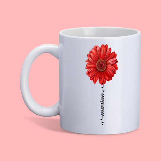 witte mok met rode gerbera en naam in sierlijk letterteken in de vorm van een bloemstengel