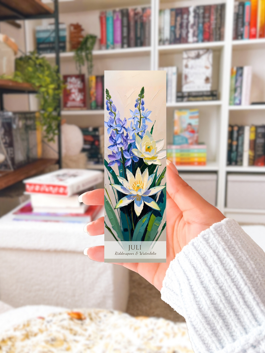 vrouw met bladwijzer in haar hand in haar woonkamer. Geboorte bloem boekenlegger voor de maand juli, met  kunstzinnige illustratie van Ridderspoor & Waterlelie.