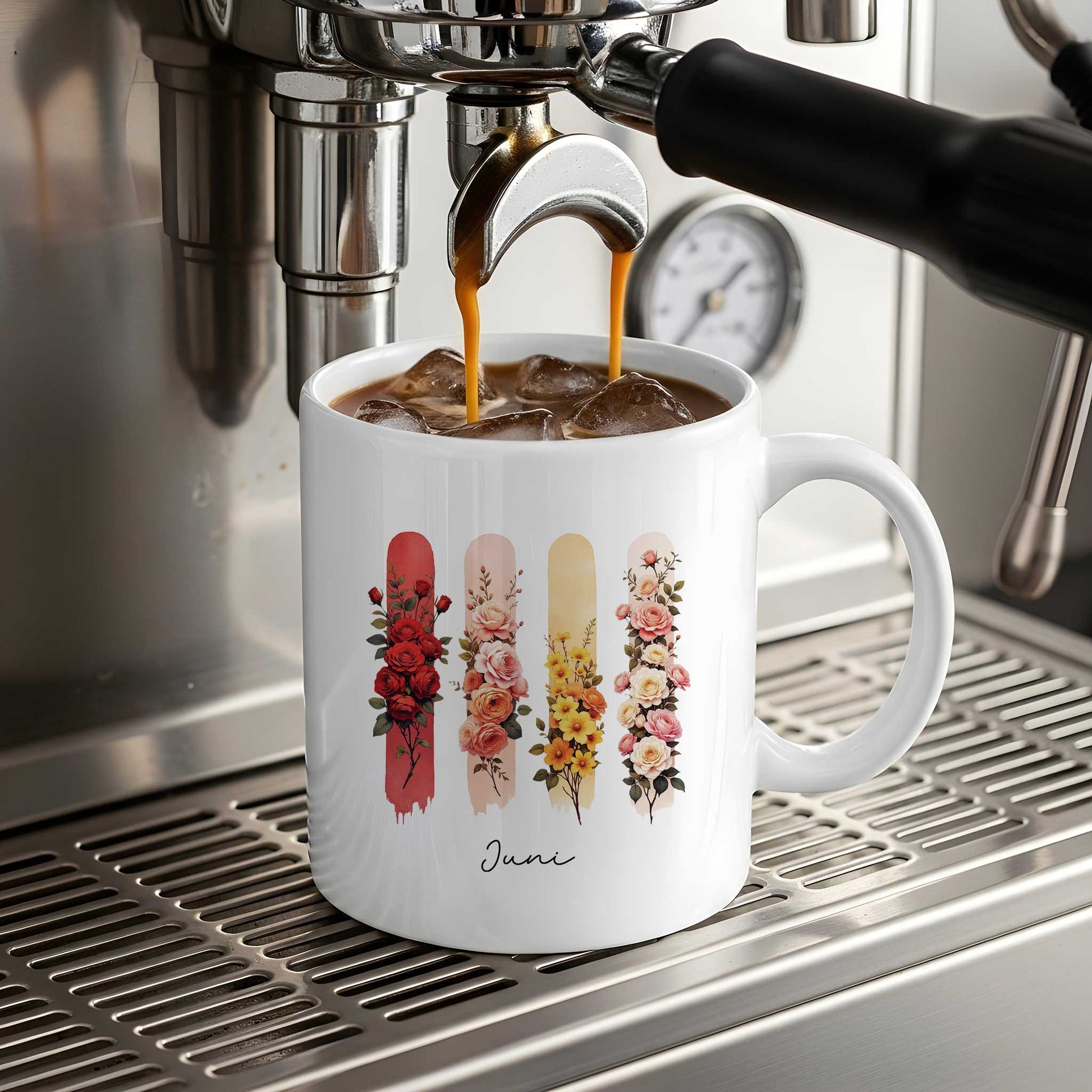 Witte mok met de geboortebloemen van juni staat onder een espressomachine terwijl koffie in de mok stroomt.