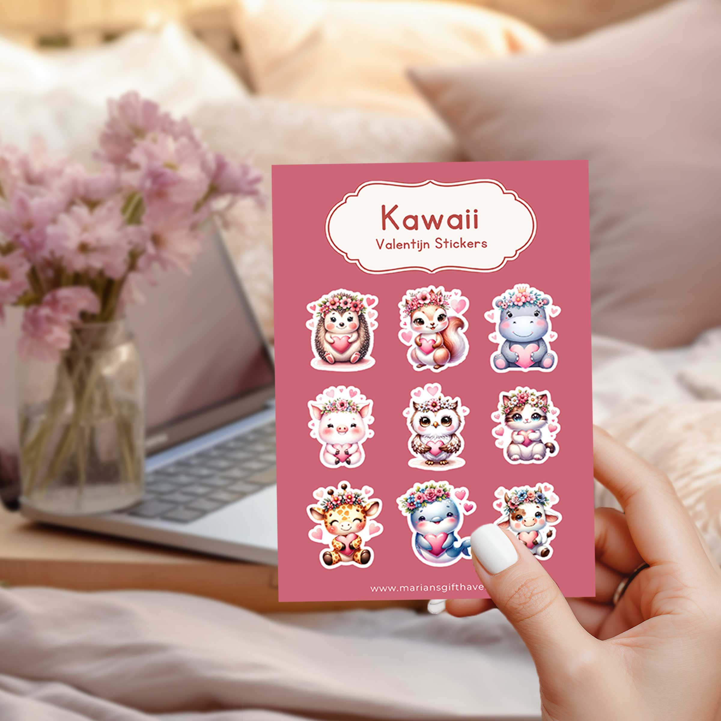 Stickervel met 9 kawaii Valentijn dierenstickers, roze achtergrond, naast laptop en bloemen