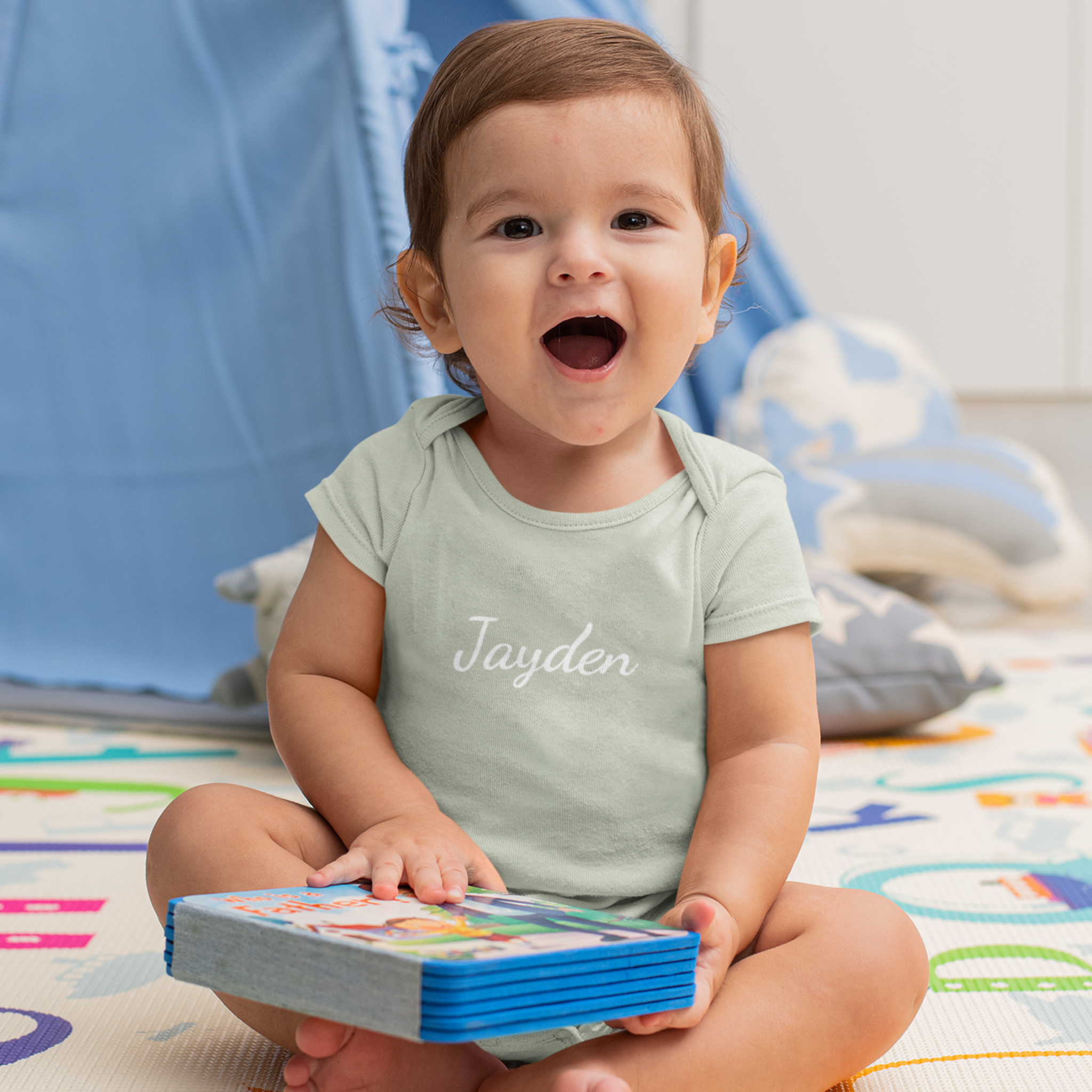 kindje die lacht met gepersonaliseerd licht groen rompertje met naam