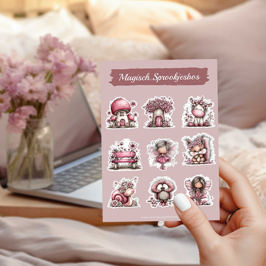 Hand houdt het stickervel Magisch Sprookjesbos vast boven een bed met op de achtergrond een laptop en een vaas met roze bloemen.